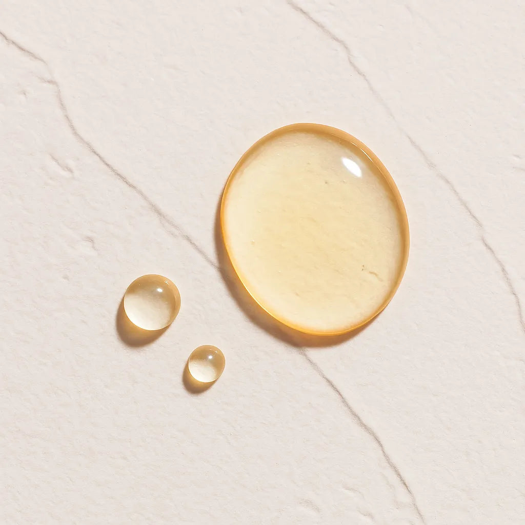 Gotas transparentes representando Ingrediente activo Peptidos Farma Dorsch con propiedades reafirmantes, antiedad y estimulantes del colageno para tratamiento facial y corporal sobre fondo blanco marmolado en cosmetica natural española