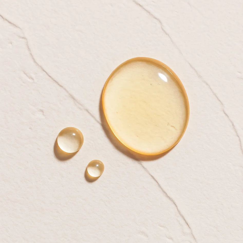 Gotas transparentes representando Ingrediente activo Peptidos Farma Dorsch con propiedades reafirmantes, antiedad y estimulantes del colageno para tratamiento facial y corporal sobre fondo blanco marmolado en cosmetica natural española