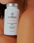 Envase del complemento alimenticio Slim & Firm de Farma Dorsch, mostrado sobre la piel, destacando su diseño limpio y elegante.