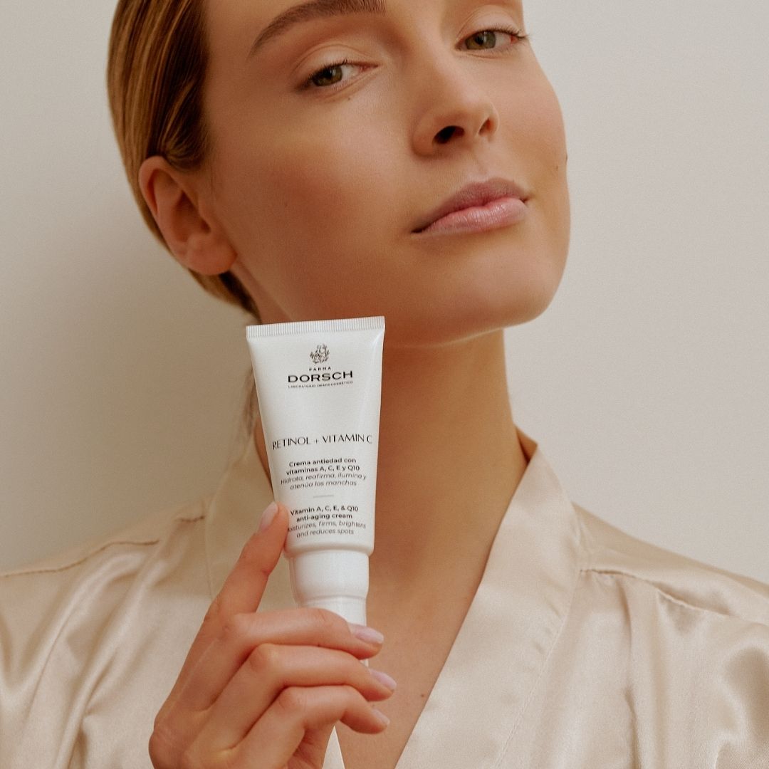 Modelo sosteniendo el tratamiento Retinol + Vitamin C de Farma Dorsch, mostrando el envase en un entorno cuidado y elegante.