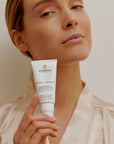 Modelo sosteniendo el tratamiento Retinol + Vitamin C de Farma Dorsch, mostrando el envase en un entorno cuidado y elegante.