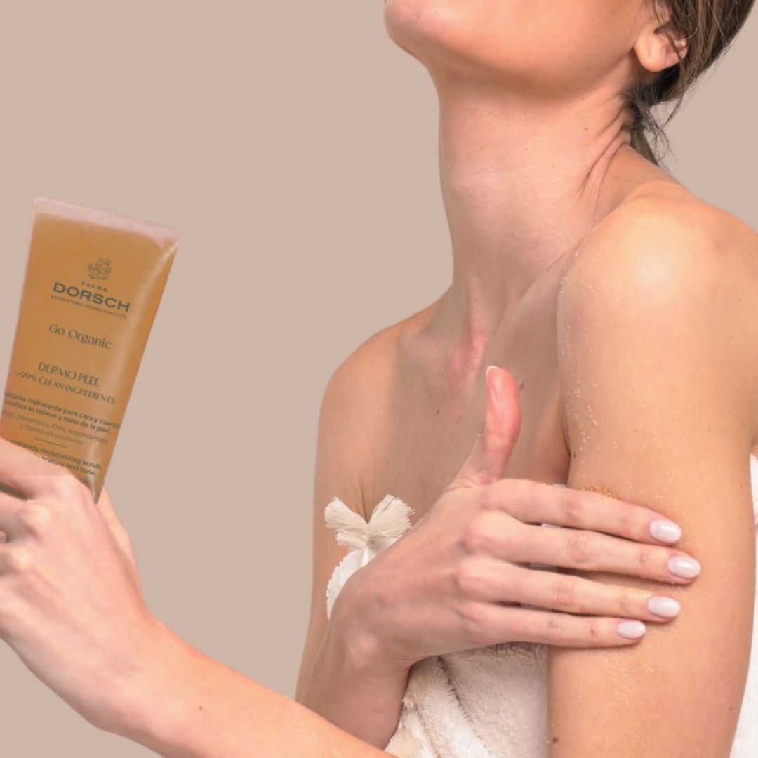 El torso de una mujer y sus manos en las que sujeta DERMO PEEL el exfoliante corporal y facial de FARMA DORSCH