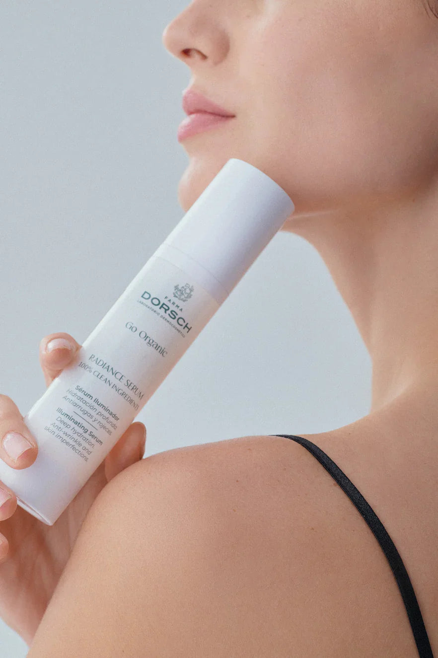 La mitad del rostro de una mujer y su mano sujetando una crema de FARMA DORSCH para hidratar tu piel en invierno