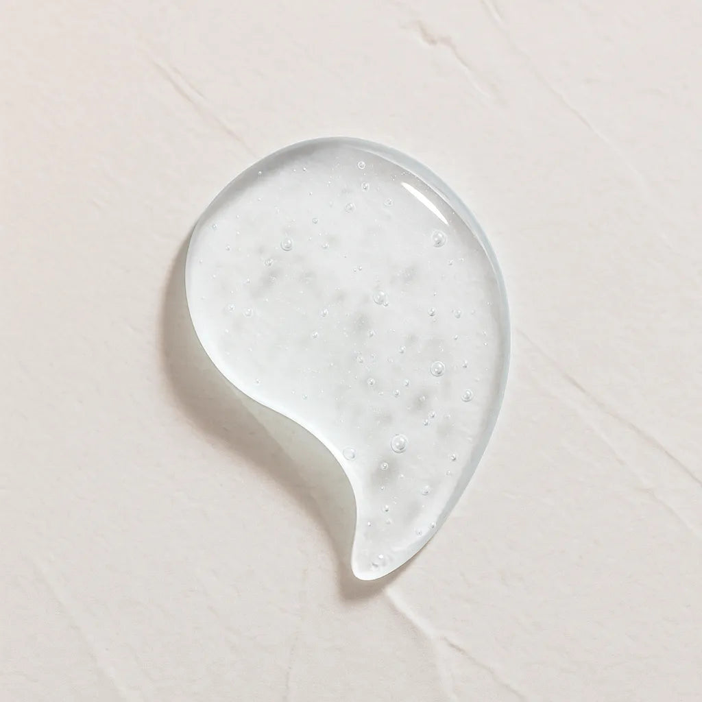 Gota transparente ligeramente amarillenta representando Ingrediente activo Acido Hialuronico Farma Dorsch para hidratacion profunda, relleno de arrugas y piel suave sobre fondo blanco texturizado en cosmetica natural española