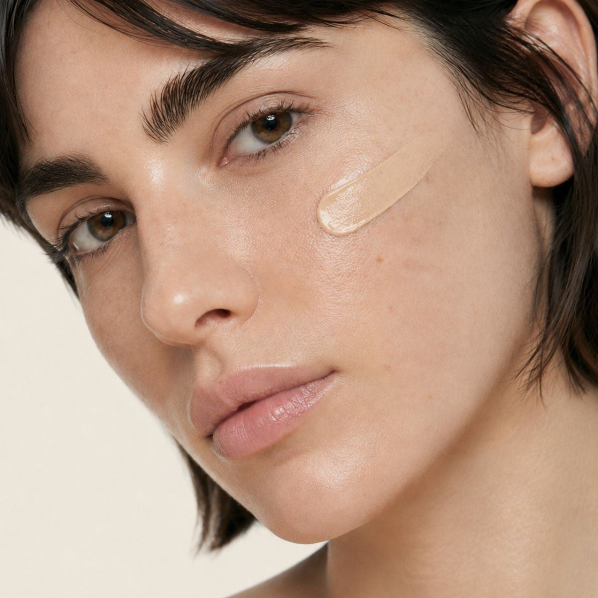 Mujer aplicándose la CC CREAM de FARMA DORSCH en la piel, crema hidratante con color, vitamina c y protección solar SPF50