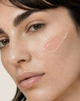 Mujer aplicando STOP AKNEIK de FARMA DORSCH en zonas con imperfecciones para cuidar la piel acneica.