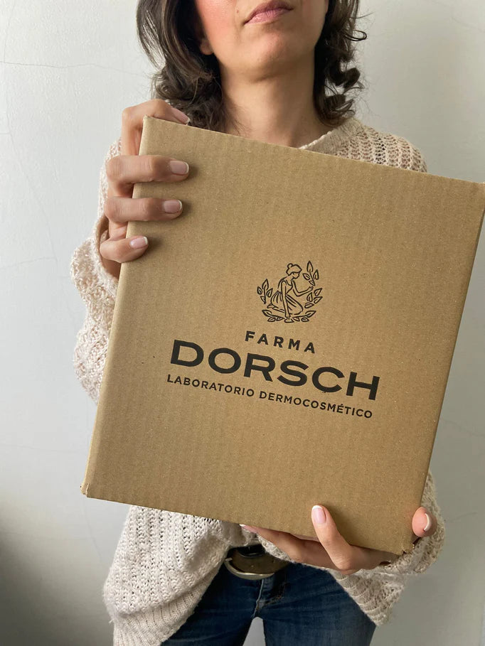 mujer sosteniendo una caja de cartón con el logo de FARMA DORSCH 