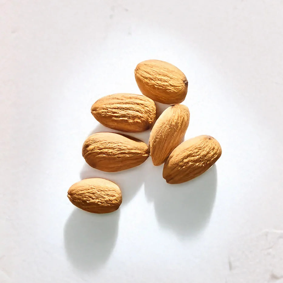 Varias almendras representando Ingrediente activo Aceite de Almendras Farma Dorsch con propiedades nutritivas, hidratantes y antioxidantes para piel y cabello sobre fondo blanco suave en cosmetica natural española