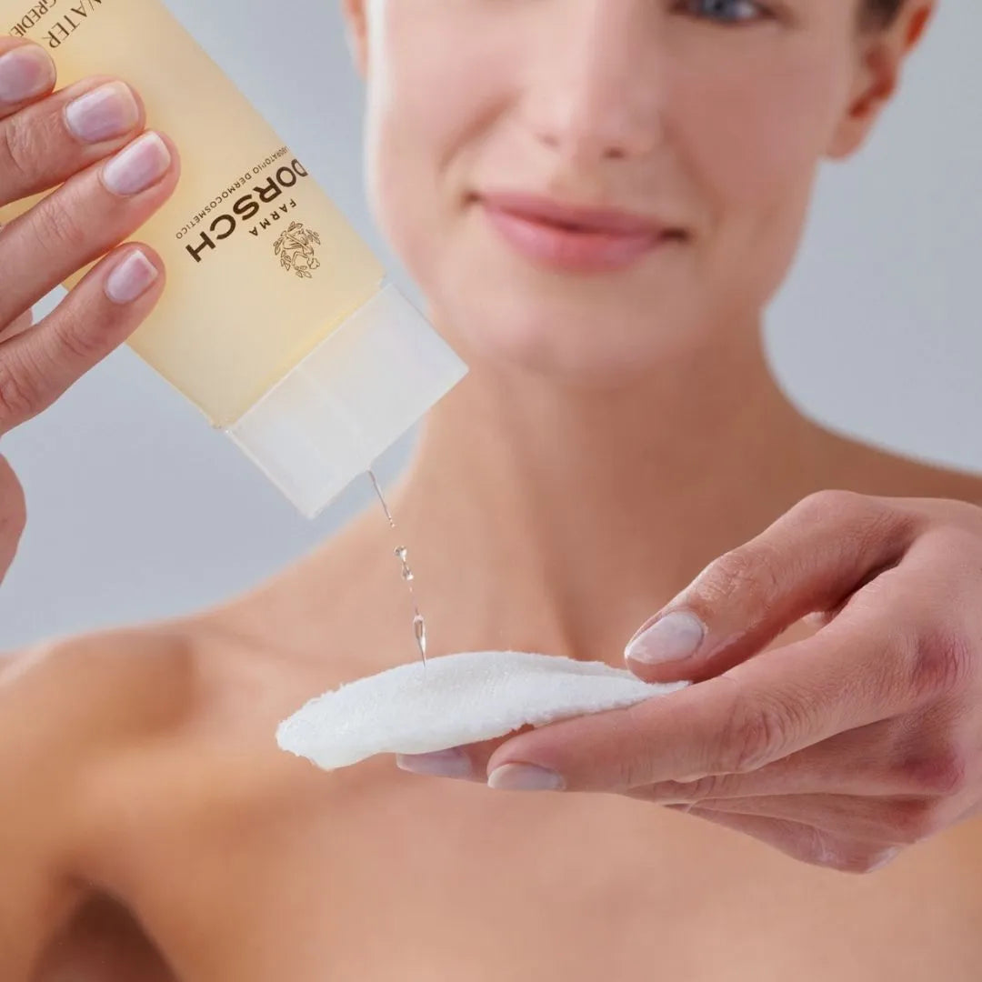 mujer aplicando agua micelar FARMA DORSCH sobre un algodón para la limpieza facial
