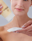 mujer aplicando agua micelar FARMA DORSCH sobre un algodón para la limpieza facial