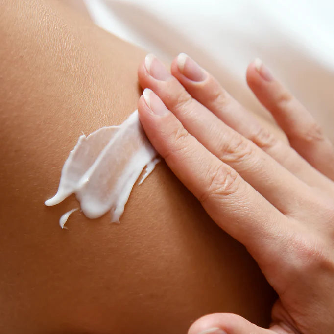 mujer aplicándose la crema corporal de FARMA DORSCH sobre la pierna