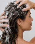 Mujer usando HAIR LOSS SHAMPOO de FARMA DORSCH para fortalecer el cabello y reducir la caída.