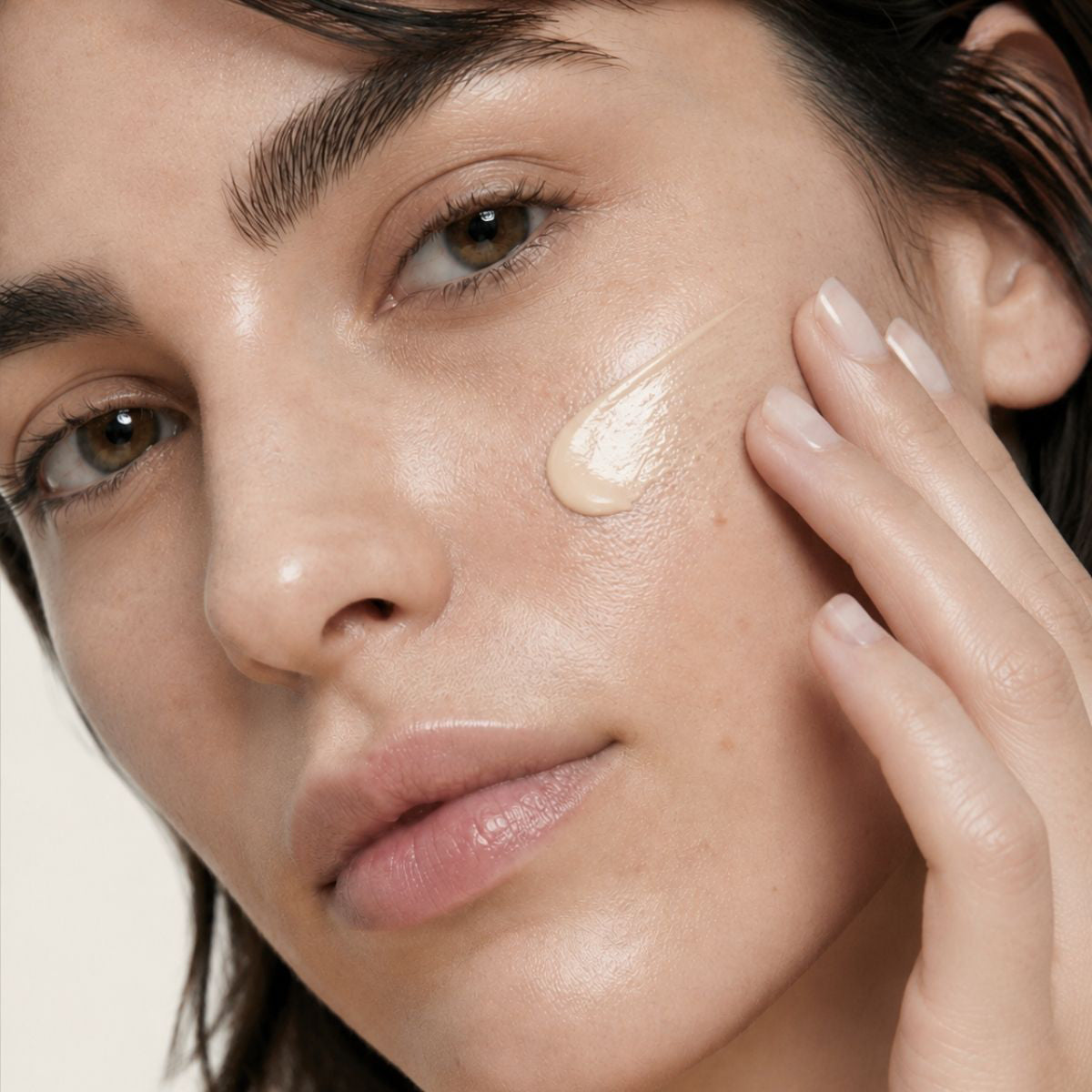 Mujer aplicándose la CC CREAM de FARMA DORSCH en la piel, crema hidratante con color, vitamina c y protección solar SPF50