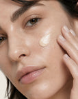 Mujer aplicándose la CC CREAM de FARMA DORSCH en la piel, crema hidratante con color, vitamina c y protección solar SPF50