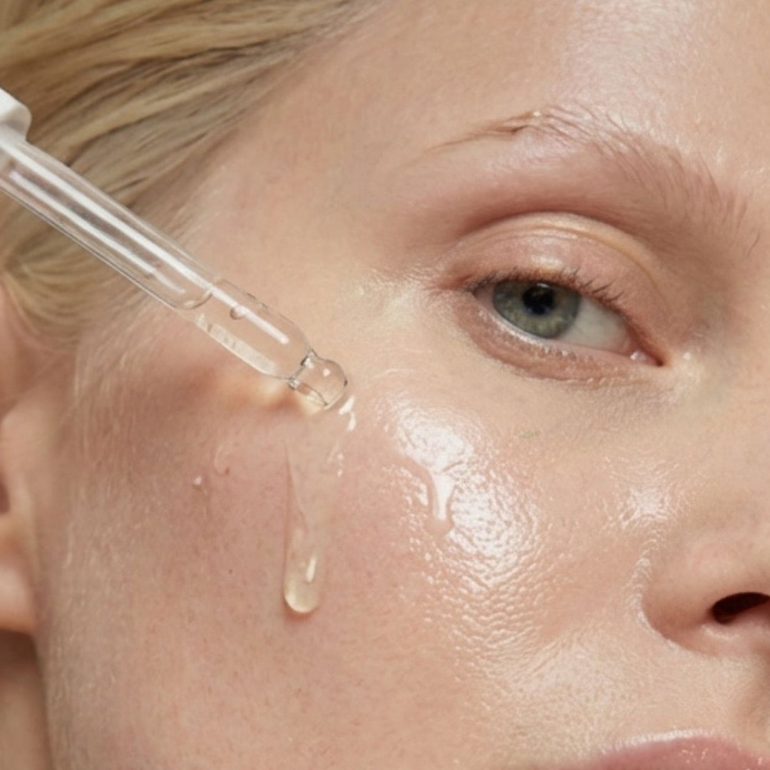 Mujer aplicando GOLD DROPS de FARMA DORSCH en el rostro para nutrir, iluminar y mejorar la elasticidad de la piel.