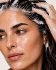 Mujer usando HAIR LOSS SHAMPOO de FARMA DORSCH para fortalecer el cabello y reducir la caída.