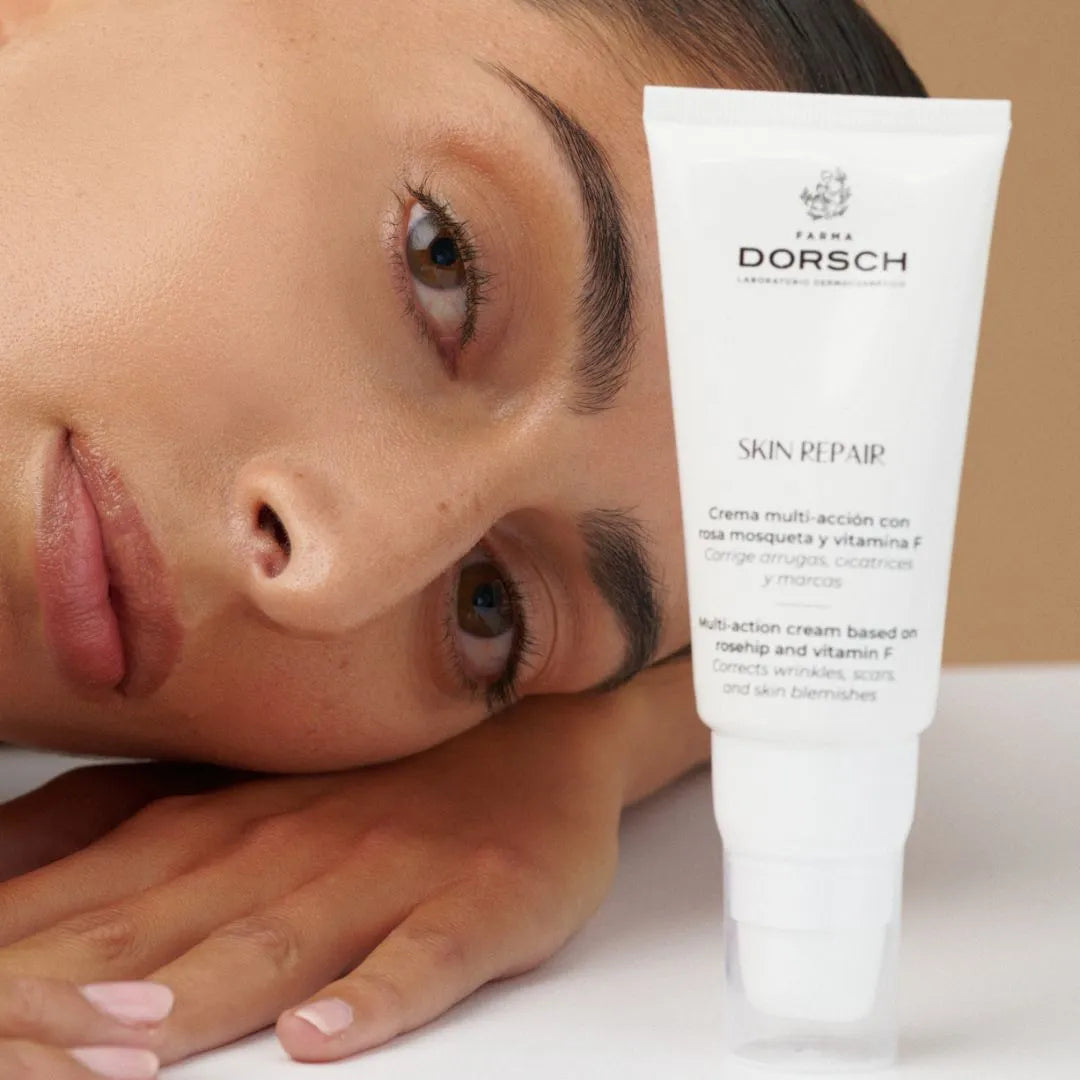 Mujer recostada junto a la crema Skin Repair de Farma Dorsch con vitamina F y rosa mosqueta, ideal para tratar arrugas, cicatrices y manchas.