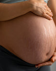 barriga de una mujer embarazada de unos 8 meses con estrías 