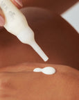 Mujer aplicándose en la mano la ampolla de Pure Silk de FARMA DORSCH en la mano 