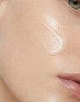Mujer aplicando RADIANCE SERUM de FARMA DORSCH en el rostro para mejorar hidratación, luminosidad y confort.