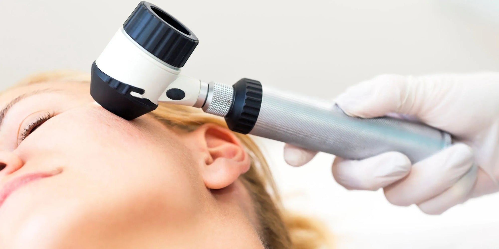 Foto de un experto analizando la piel de una mujer para hacerle una recomendación