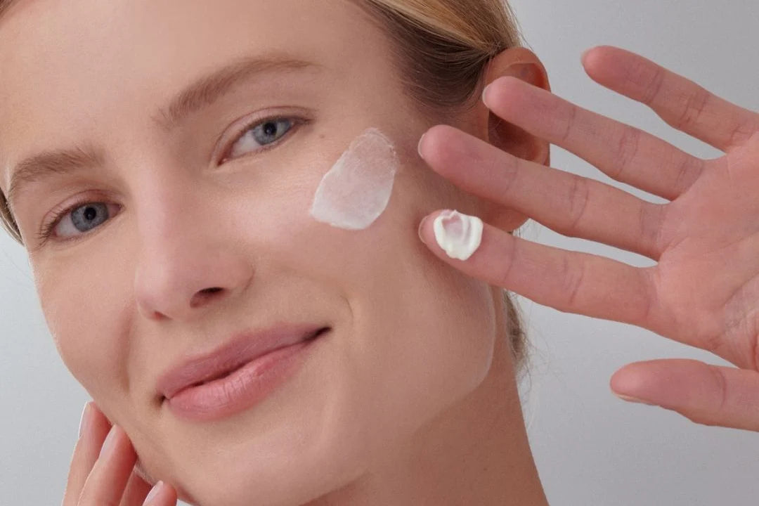 Mujer aplicando la crema facial SPF 50 CREAM de FARMA DORSCH en la mejilla, mostrando su textura ligera y fundente. Fotoprotector con muy alta protección, ideal para el cuidado diario de pieles sensibles. Hidrata, protege frente al fotoenvejecimiento y deja un acabado natural. fotoprotección alta