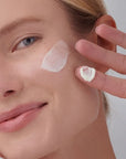 Mujer aplicando la crema facial SPF 50 CREAM de FARMA DORSCH en la mejilla, mostrando su textura ligera y fundente. Fotoprotector con muy alta protección, ideal para el cuidado diario de pieles sensibles. Hidrata, protege frente al fotoenvejecimiento y deja un acabado natural. fotoprotección alta