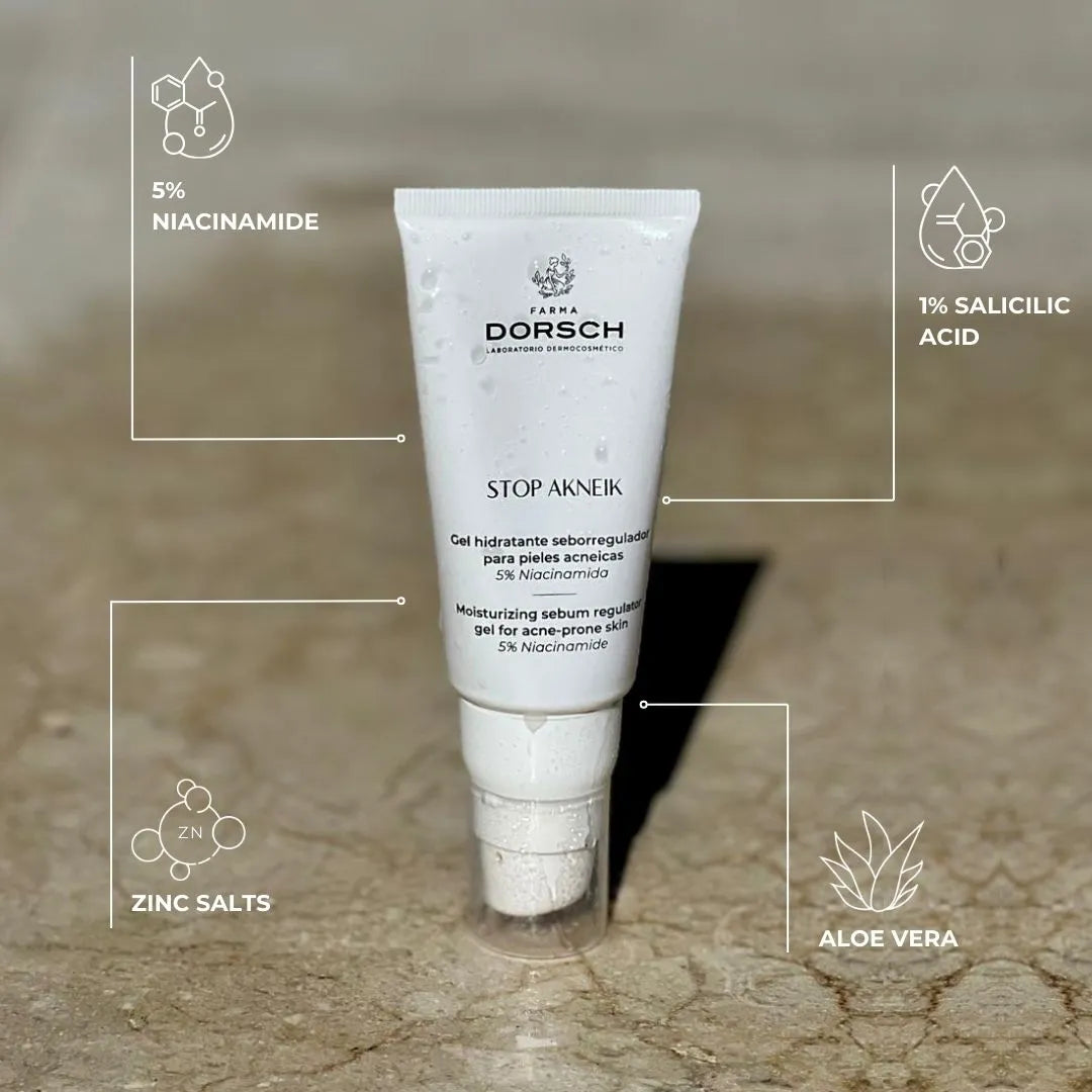 Imagen del gel STOP AKNEIK de FARMA DORSCH sobre superficie de mármol mojada, con gotas visibles en el envase. Fórmula clean ingredients con 5% niacinamida, 1% ácido salicílico, sales de zinc y aloe vera, diseñada para pieles acneicas. Hidrata, regula el sebo y calma la piel con imperfecciones.