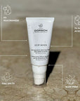Imagen del gel STOP AKNEIK de FARMA DORSCH sobre superficie de mármol mojada, con gotas visibles en el envase. Fórmula clean ingredients con 5% niacinamida, 1% ácido salicílico, sales de zinc y aloe vera, diseñada para pieles acneicas. Hidrata, regula el sebo y calma la piel con imperfecciones.