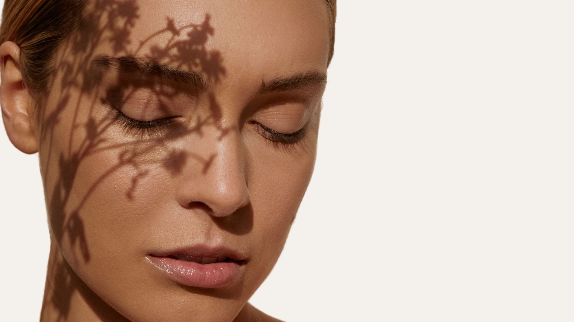 Primer plano de una mujer con sombra de plantas en el rostro, imagen para portada de tratamientos antimanchas de Farma Dorsch.